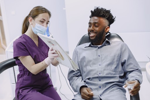 Dentist explaining dental treatment information to a patient during a consultation.