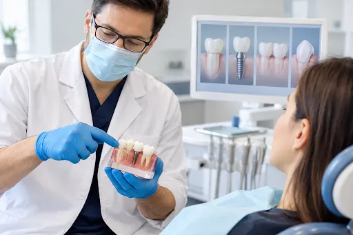 Dentist explaining tooth restoration options to a patient using a dental model.